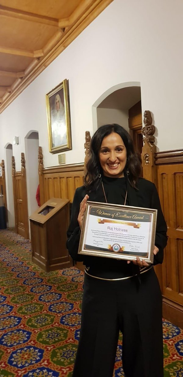 Raj Holness receiving the Women of Excellence Award at Parliament